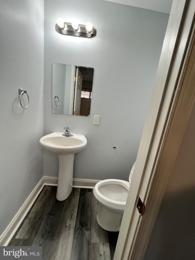 bathroom featuring hardwood / wood-style flooring and toilet