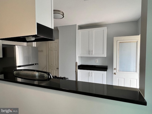 kitchen with white cabinets and stainless steel refrigerator