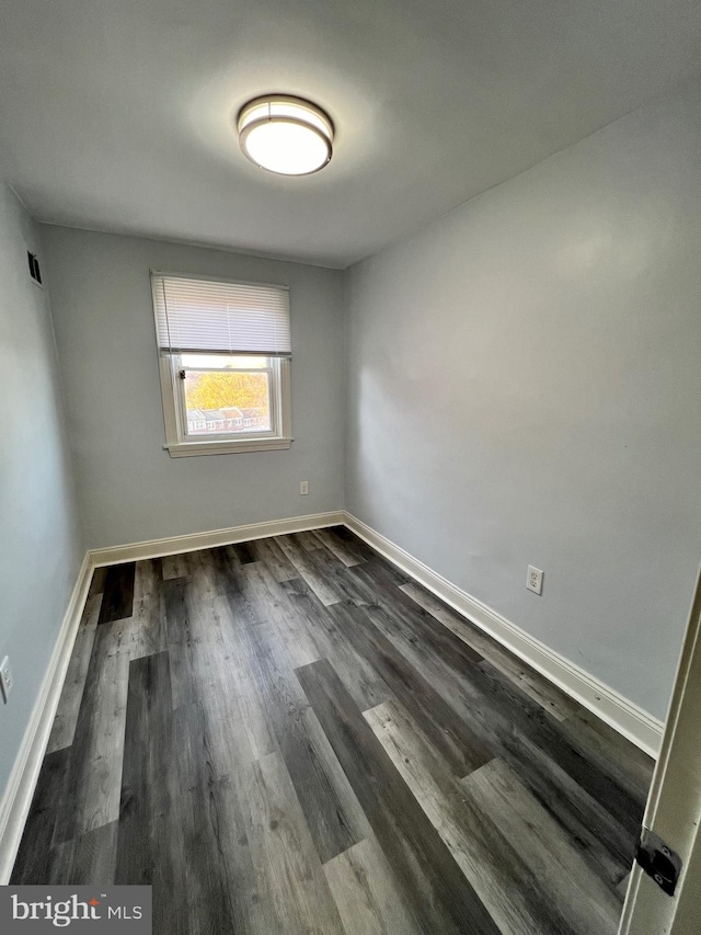 unfurnished room with dark wood-type flooring