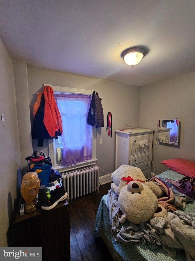 bedroom featuring radiator and dark hardwood / wood-style floors