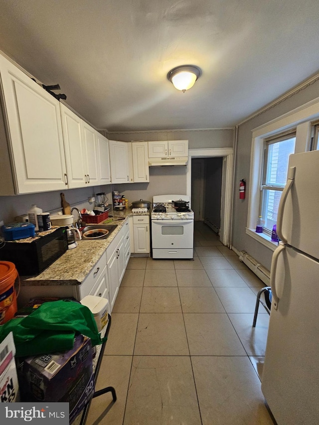 kitchen with white cabinets, light tile patterned floors, white appliances, and sink