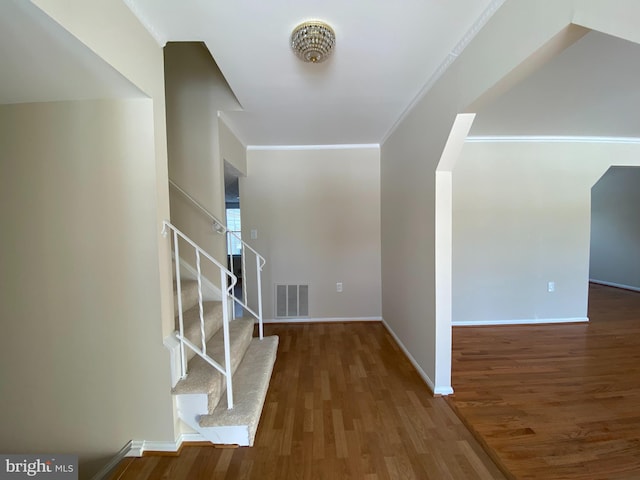 foyer entrance featuring ornamental molding and dark hardwood / wood-style floors