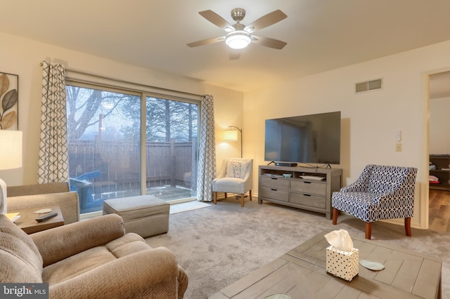 carpeted living room featuring ceiling fan