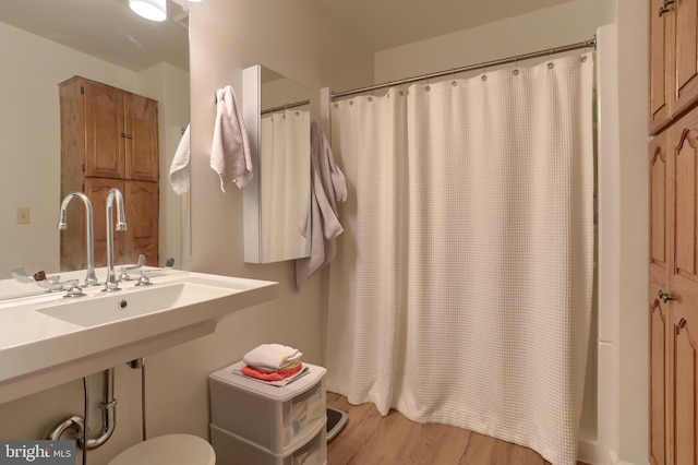 bathroom with curtained shower and wood-type flooring