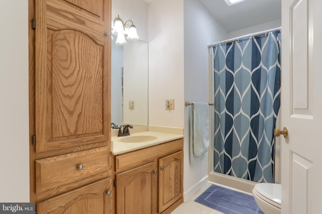 bathroom featuring tile patterned floors, vanity, toilet, and walk in shower