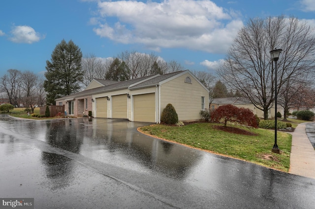 view of home's exterior featuring a garage and a lawn