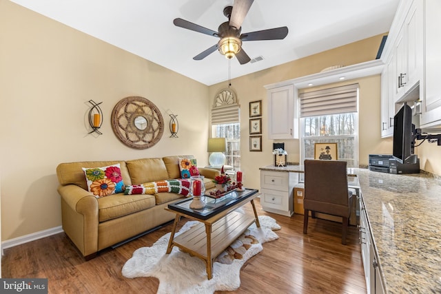 living room featuring ceiling fan and dark hardwood / wood-style flooring