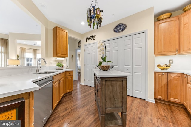 kitchen with a center island, sink, stainless steel dishwasher, a notable chandelier, and dark hardwood / wood-style flooring