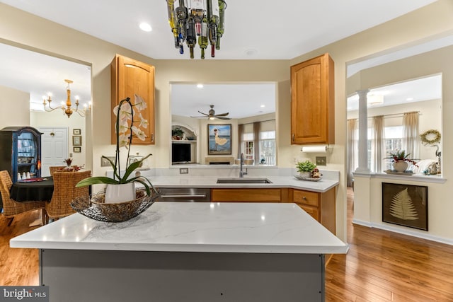 kitchen with kitchen peninsula, a wealth of natural light, sink, and light hardwood / wood-style floors