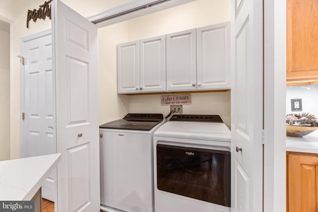 laundry room featuring cabinets and separate washer and dryer