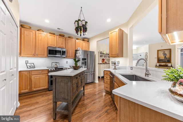 kitchen featuring a chandelier, stainless steel appliances, light hardwood / wood-style flooring, and sink