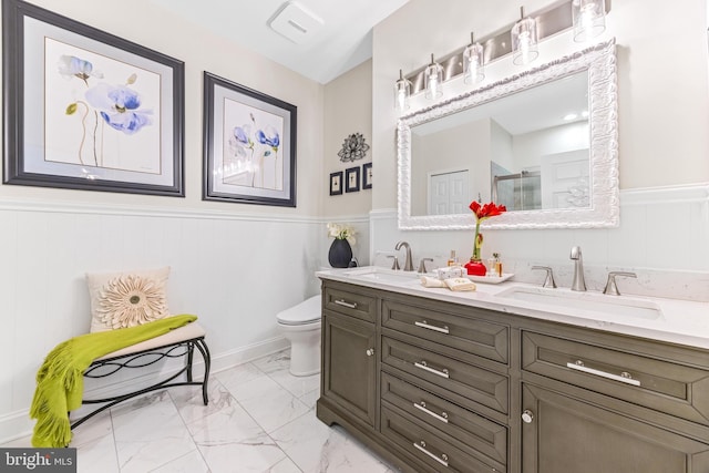 bathroom with vanity, toilet, and a shower with door