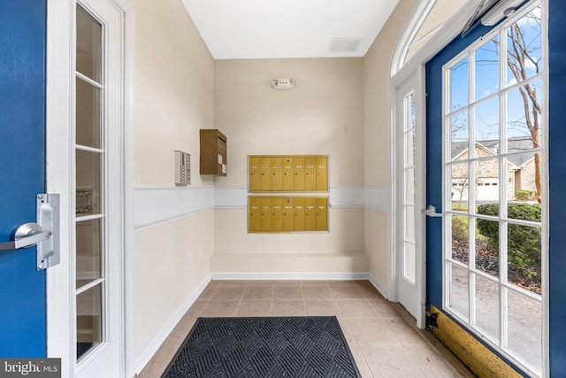 entryway featuring light tile patterned floors and mail boxes