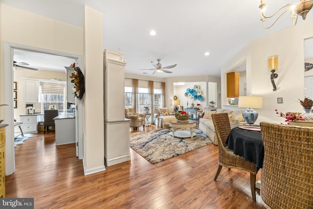 dining area featuring hardwood / wood-style floors, a healthy amount of sunlight, and ceiling fan with notable chandelier