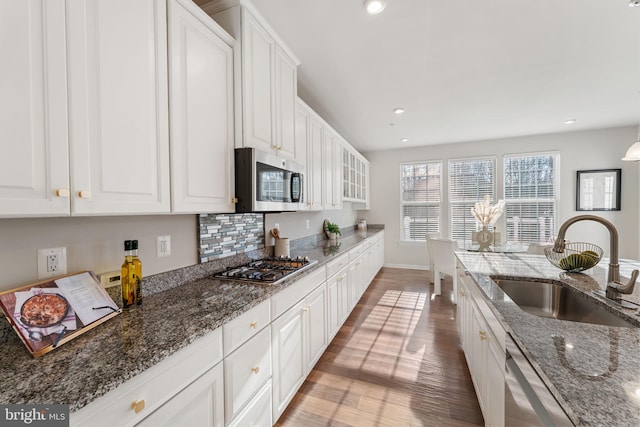 kitchen with dark stone countertops, sink, white cabinets, and stainless steel appliances