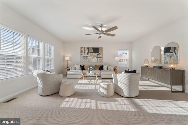 carpeted living room with ceiling fan