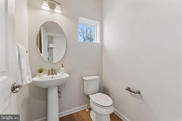 bathroom featuring sink, wood-type flooring, and toilet