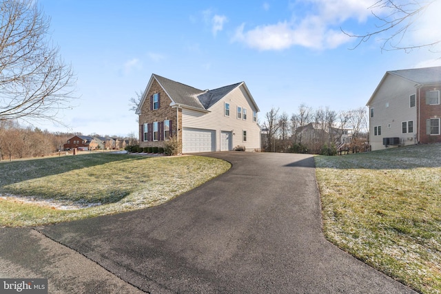 view of side of home with a garage and a lawn