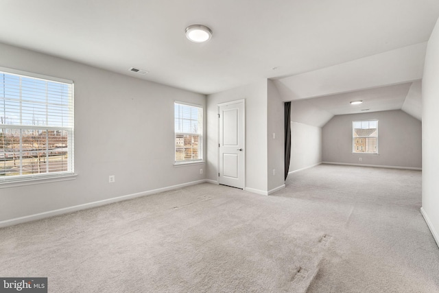 additional living space with light colored carpet and lofted ceiling