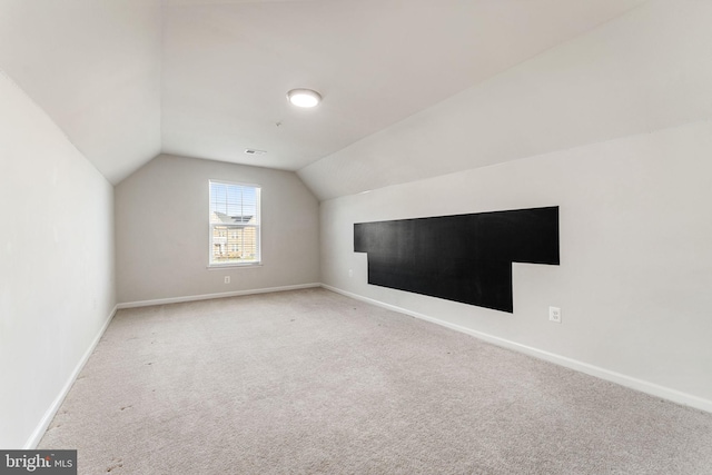 bonus room featuring carpet flooring and vaulted ceiling