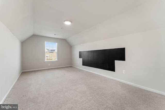 bonus room with carpet flooring and vaulted ceiling