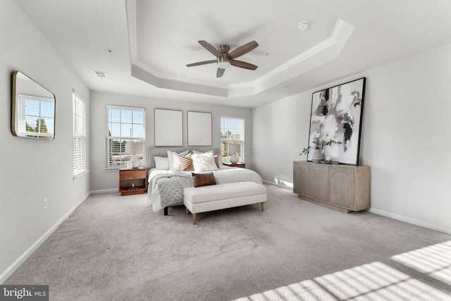 bedroom with a tray ceiling, ceiling fan, crown molding, and light carpet