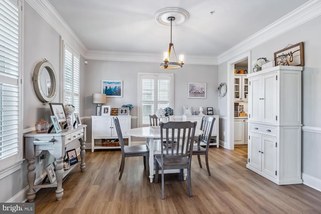 dining room with a chandelier, light hardwood / wood-style floors, and ornamental molding