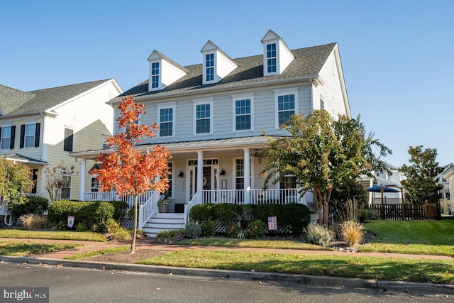 view of front of home with covered porch and a front lawn