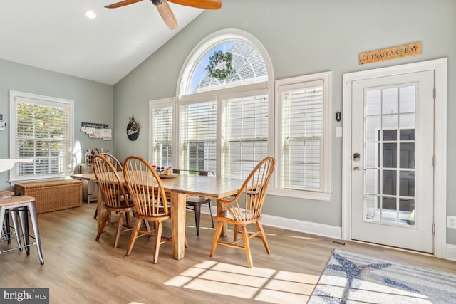 dining room featuring plenty of natural light, ceiling fan, lofted ceiling, and light hardwood / wood-style flooring