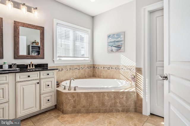 bathroom with tile patterned flooring, vanity, and tiled bath