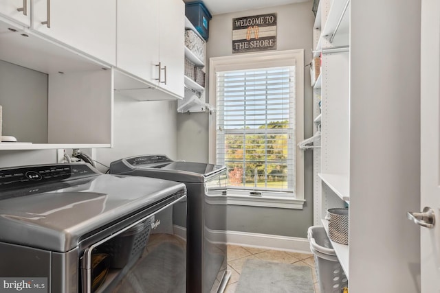 laundry room with cabinets, independent washer and dryer, light tile patterned floors, and plenty of natural light