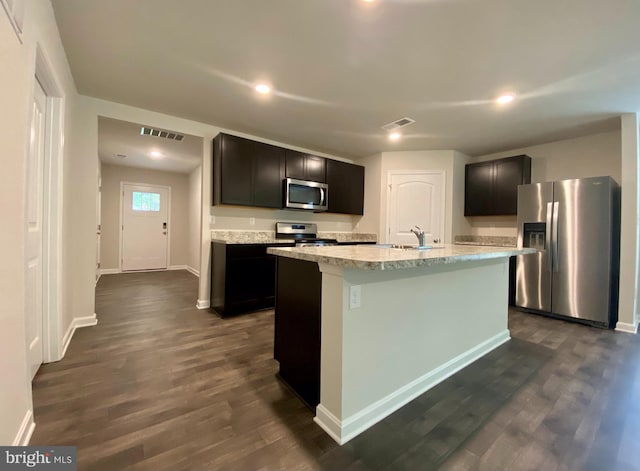 kitchen featuring dark hardwood / wood-style flooring, an island with sink, stainless steel appliances, and sink