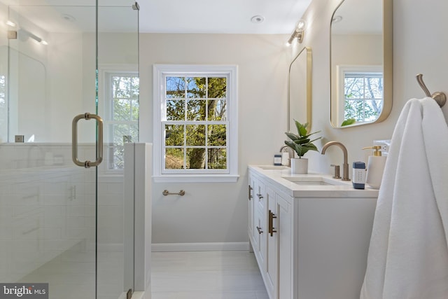 bathroom featuring vanity, an enclosed shower, and a wealth of natural light