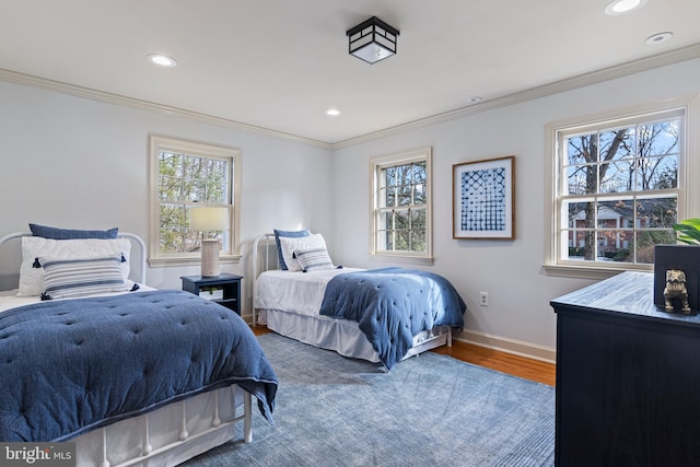 bedroom featuring multiple windows, crown molding, and hardwood / wood-style floors