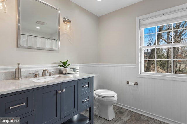 bathroom with vanity, hardwood / wood-style floors, curtained shower, and toilet