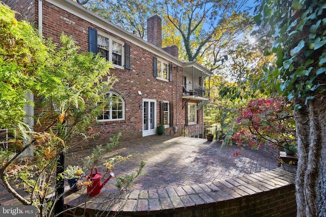 wooden terrace featuring a patio and french doors