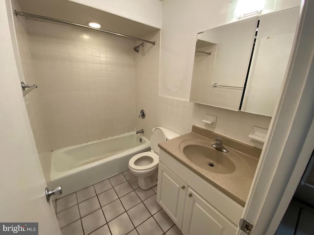 full bathroom with tasteful backsplash, tile patterned floors, vanity, tiled shower / bath combo, and toilet