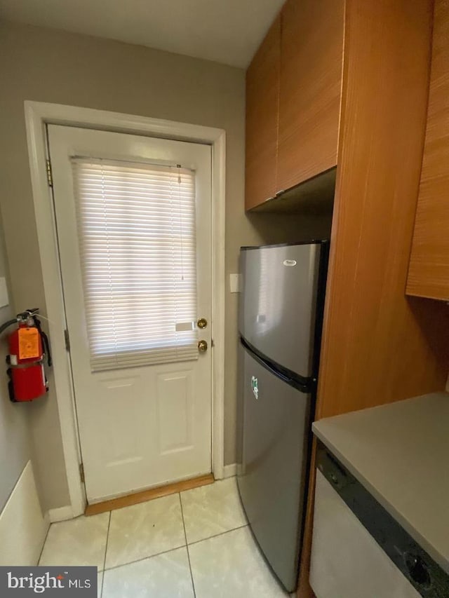 doorway to outside with light tile patterned floors