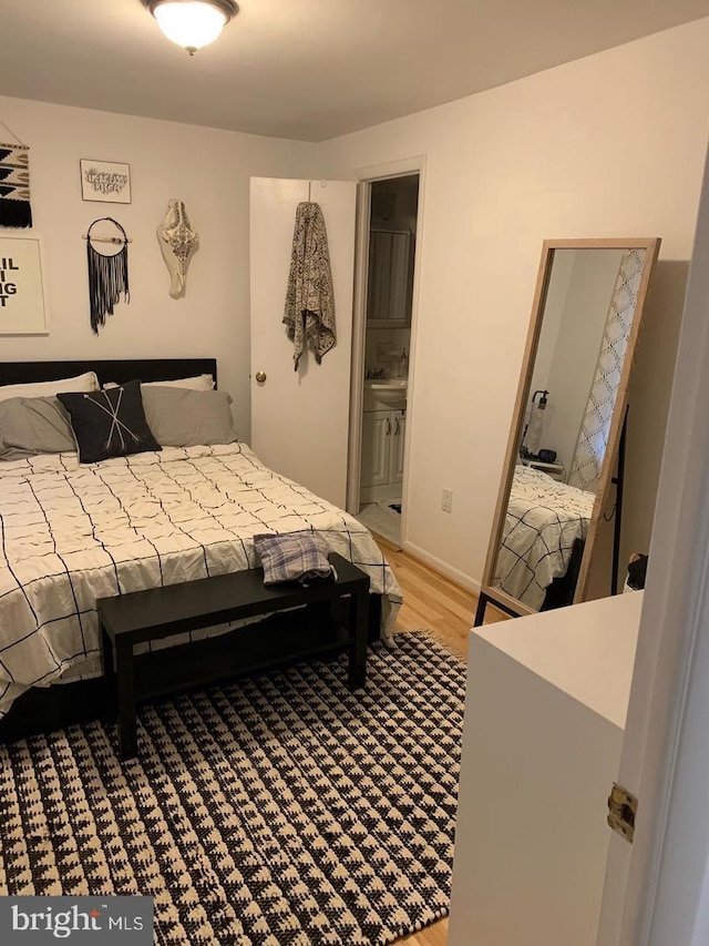 bedroom with hardwood / wood-style flooring and ensuite bath