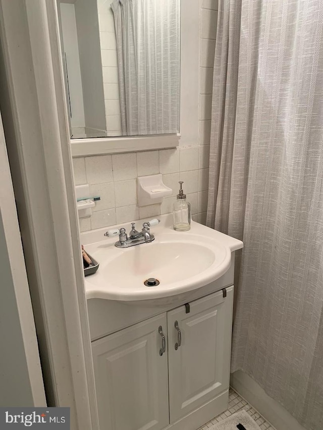 bathroom featuring tile patterned floors, decorative backsplash, vanity, and tile walls