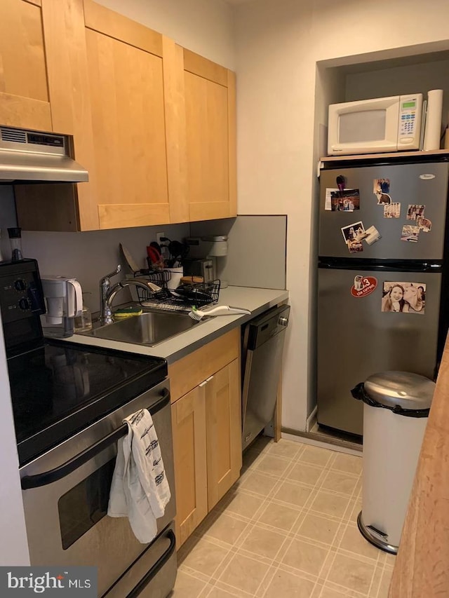 kitchen with light brown cabinets, stainless steel appliances, extractor fan, and sink