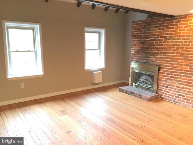 unfurnished living room with a fireplace and light hardwood / wood-style floors