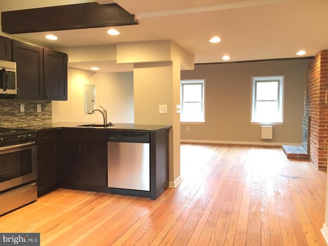 kitchen featuring light hardwood / wood-style floors, sink, backsplash, and appliances with stainless steel finishes