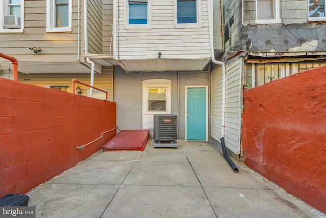 view of exterior entry featuring a patio and cooling unit