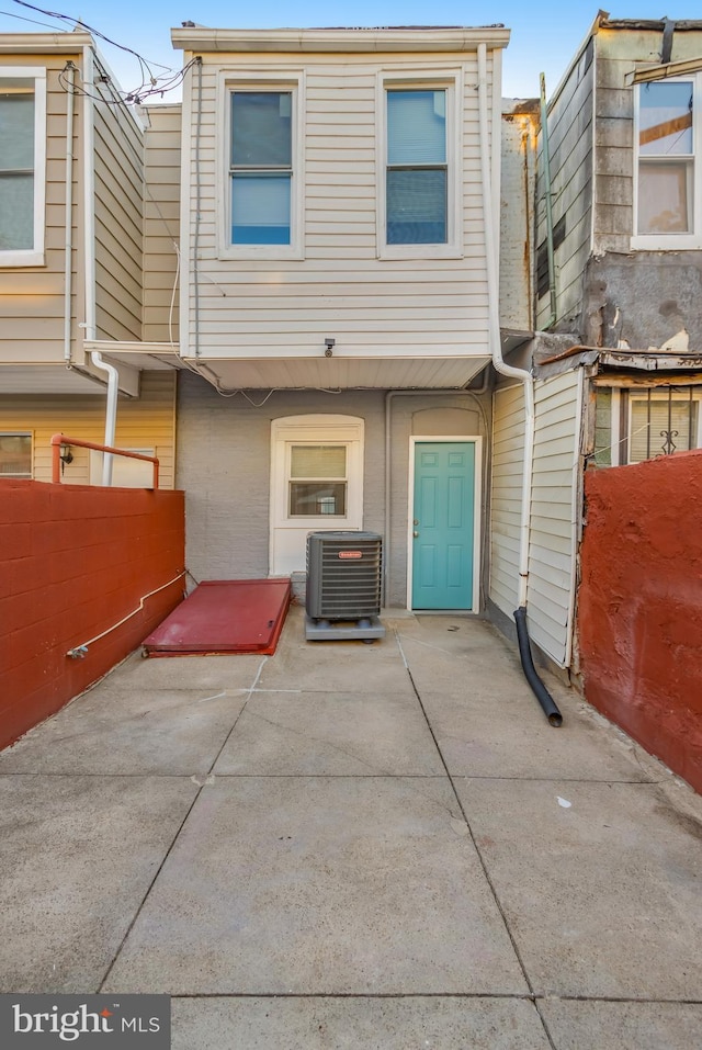 rear view of property featuring a patio and central AC