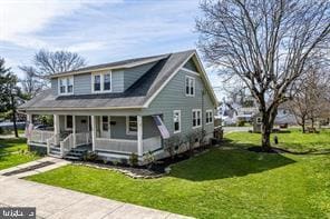 view of front of home with covered porch and a front yard