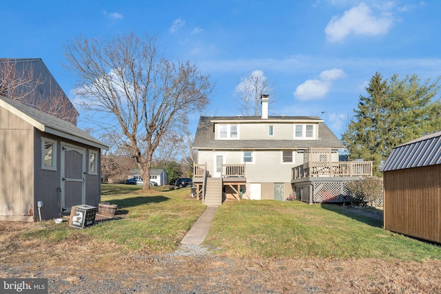 back of house featuring a storage shed, a deck, and a yard