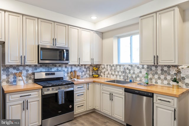 kitchen featuring appliances with stainless steel finishes, butcher block countertops, and sink