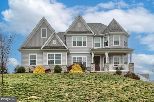 view of front of house with a porch and a front lawn