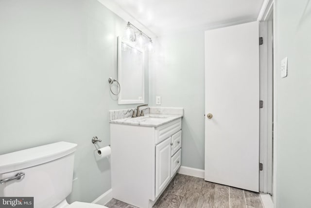 bathroom featuring vanity, toilet, and wood-type flooring